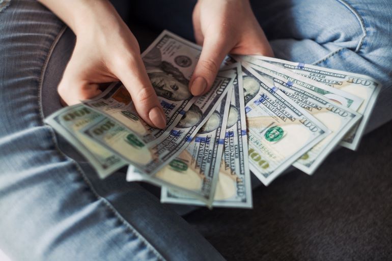  aperson holding doillars i order to pay for teh coists of remodeling your home
