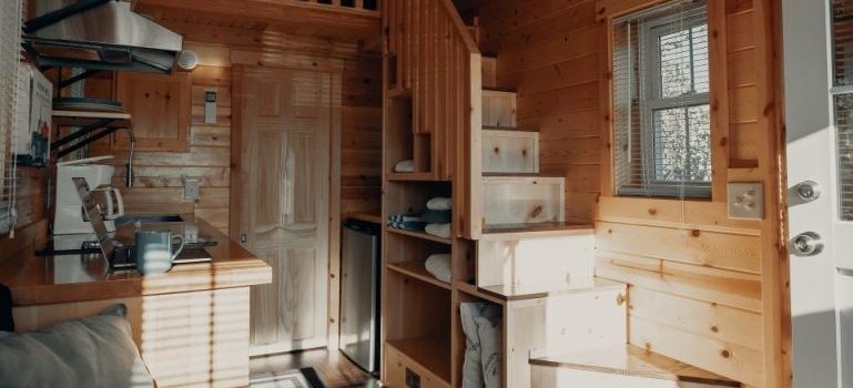 a small kitchen with well-used space below the wooden stairs