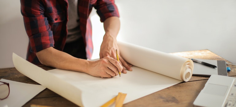 A man drawing a plan of how to prepare furniture for storage.