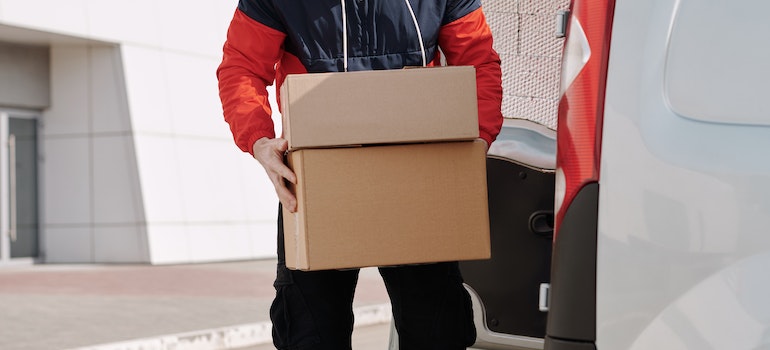 A man carrying a box he's going to take to a self storage unit.