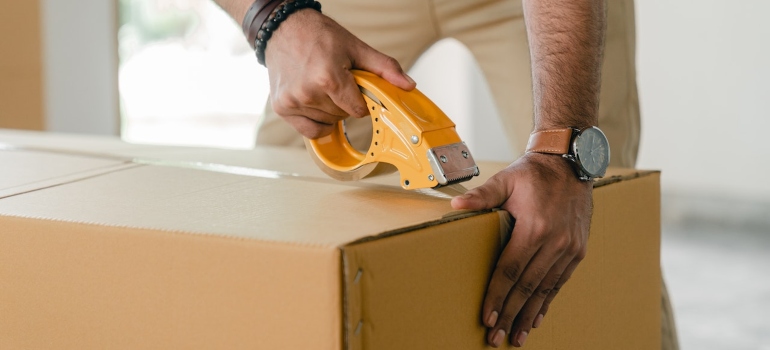 a man closing a moving box 