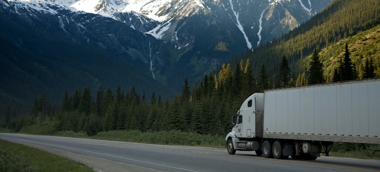 a white moving truck on a mountain road