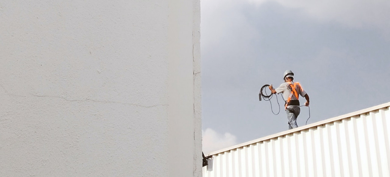 A construction worker on a roof represents industries that benefit from portable storage