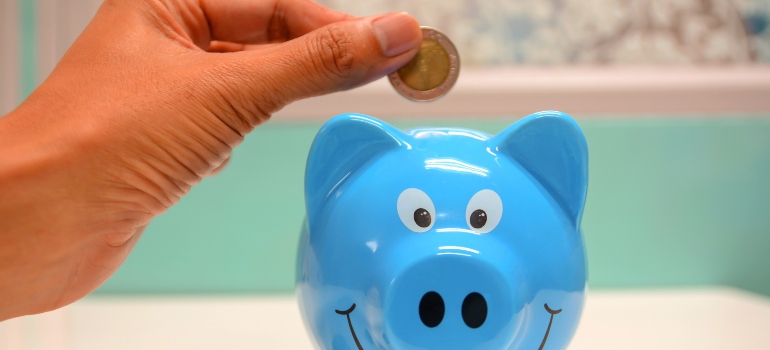 person putting coins in the piggy bank because portable storage saves you money