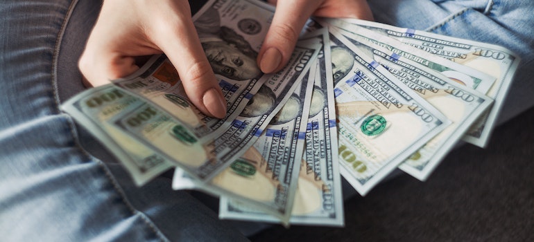 a person holding money to pay for using storage pods for a move