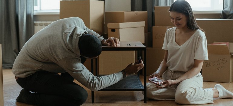 A couple is preparing furniture for loading a storage pod safely