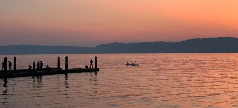 A lake with a canoe at sunset
