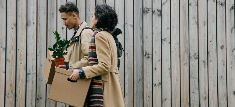 Two people carrying boxes before using storage pods for a move