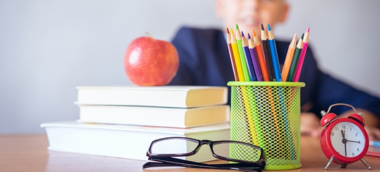 a child at the desk with school supplies