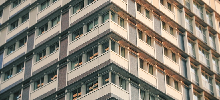 A low-angle picture of a building with many condominiums. 