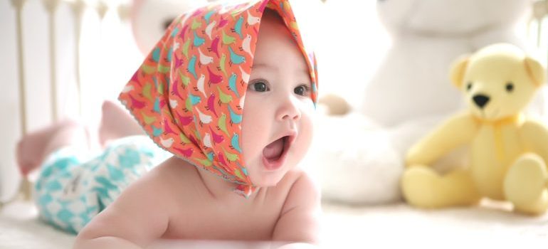 A baby wearing a scarf on their head