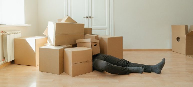 Man covered in boxes awaiting for Bellevue Self Storage workers to arrive and assist in moving the boxes