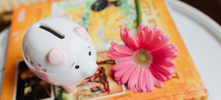 Picture of a piggy bank next to a flower