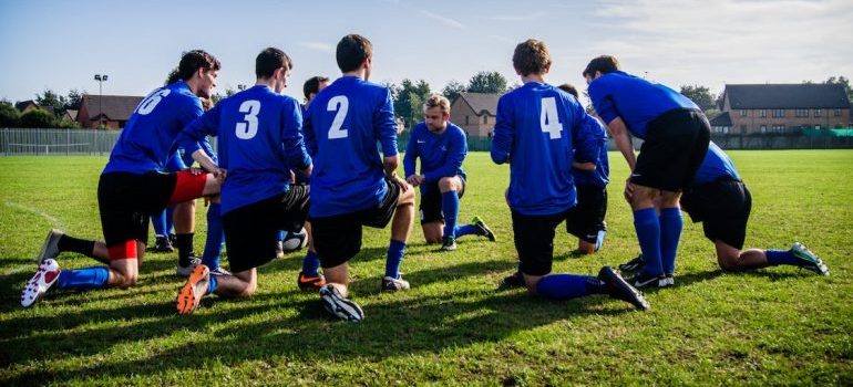 A sports team sitting in a circle and talking after storing gear in mobile storage for Seattle's sports teams