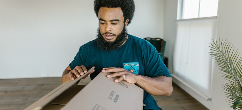 man packing a moving box