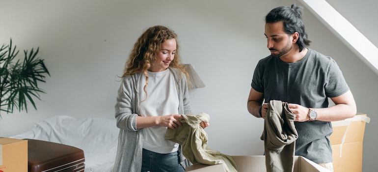 a couple folding clothes and planning on surviving the summer move in Seattle with on-demand storage 