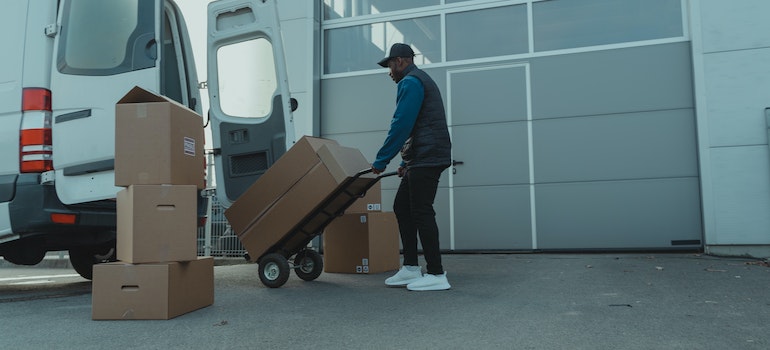 Delivery Man pulling a Trolley with Carton Boxes