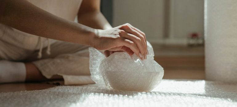 Hands packing an item in a bubble wrap