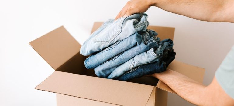 Man putting jeans into a box