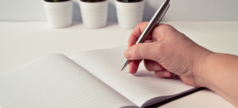 person writing Checklist for Packing a Mobile Container