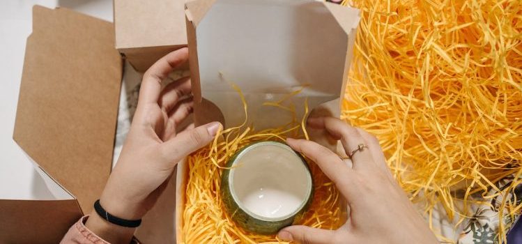A person packing a cup in the box