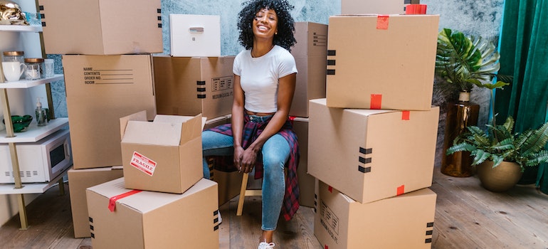 Woman smiling is surrounded by boxes
