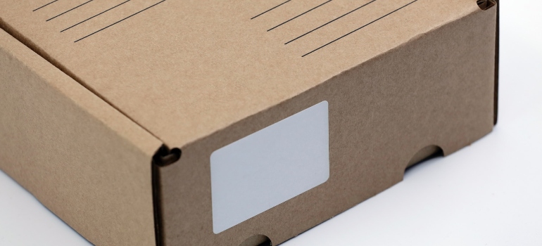 A blank cardboard delivery shipping box with a blank white address label