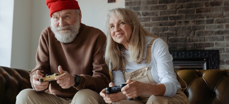 Man in red knit cap and woman in white long sleeve shirt play video games