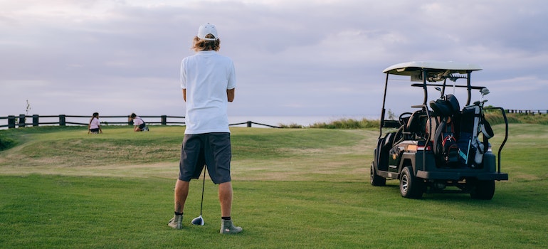 Man wearing white polo shirt playing golf