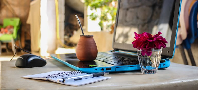 White notebook beside blue laptop computer require managing belongings while you travel