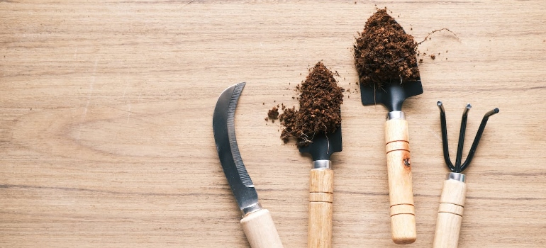 Garden tools with soil on a wooden table before storing gardening tools in Lynnwood