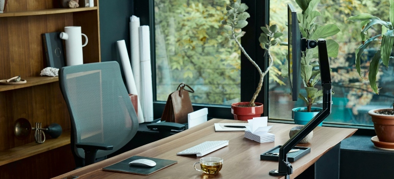 a desk with a laptop on it in front of a window