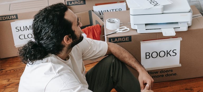 A man Sitting Beside Packed Boxes