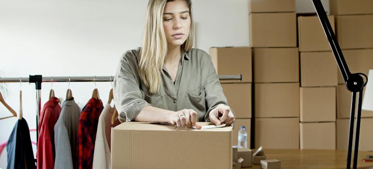 Woman Putting the Sticker on the Box to overcome seasonal storage challenges