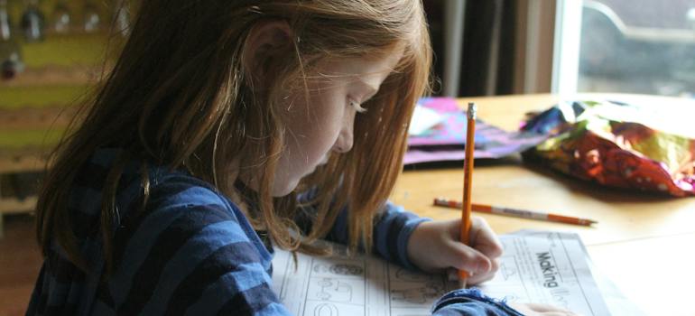 Girl Drawing On Brown Wooden Table