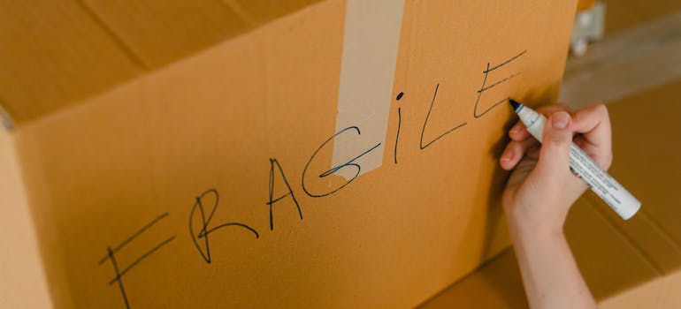 A person labeling a box Fragile