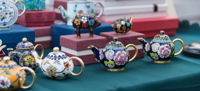Purple and white floral teapots on blue textile