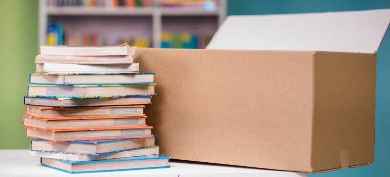 A stack of books on a table next to a box