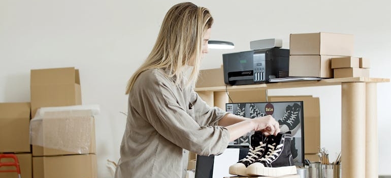 Woman Holding Black Shoes on Top of the Box