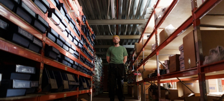 Man in green Shirt Standing in the Storeroom