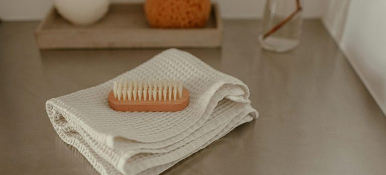 A towel and a brush neatly placed on a counter, reminding to pack bathroom items when moving for a smooth transition