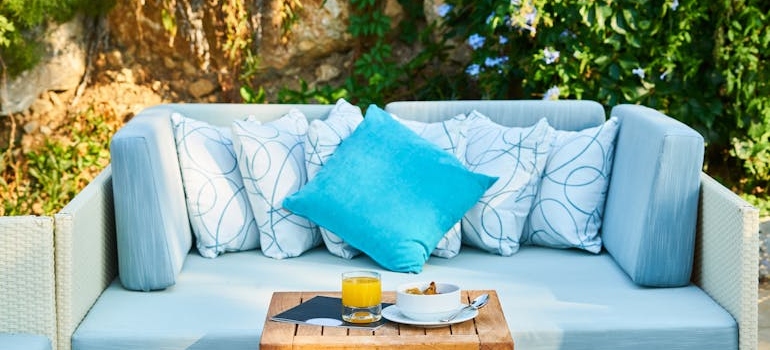 Blue throw pillow and brown wooden table in a yard