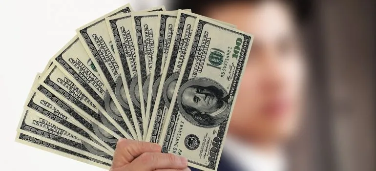 A man holding dollar bills to pay for portable storage solutions for students in Seattle