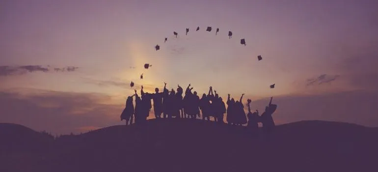 A group of graduates throwing their graduation hats.
