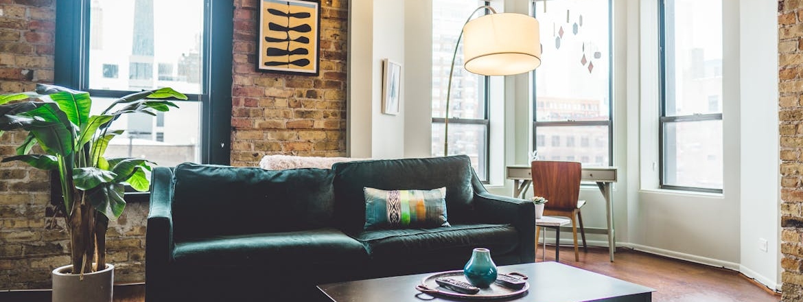 A green 2-seat sofa in a room after you maximize your apartment space.