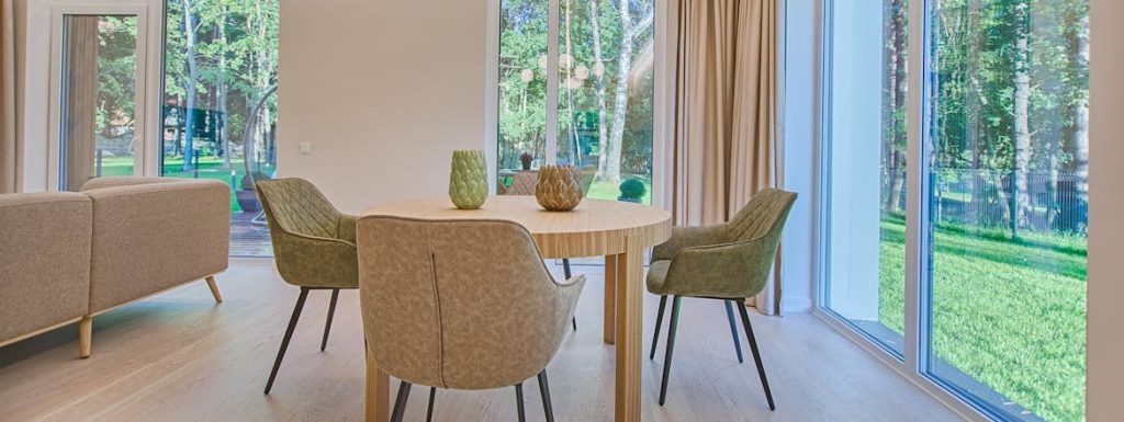 Round brown wooden 5-piece dining set in a living room.